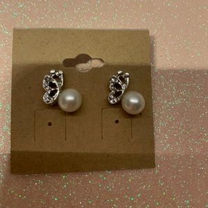Beautiful silver tone butterfly holding a white pearl stud earrings